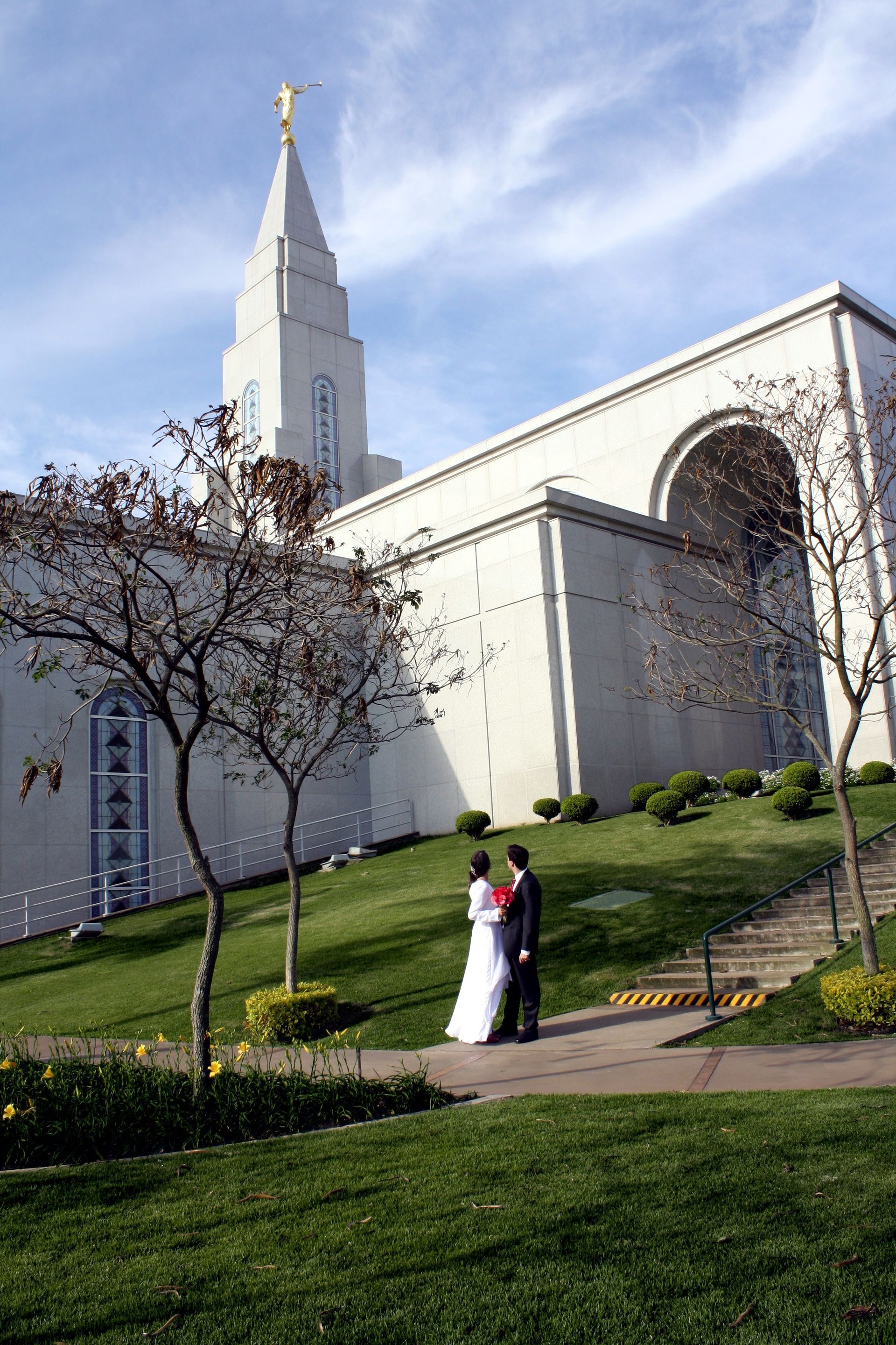 A bride and groom standing and looking at the Campinas Brazil Temple.