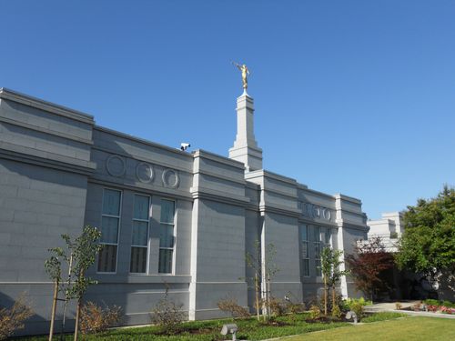 A side view of the Fresno California Temple with the spire at the top in the daytime.