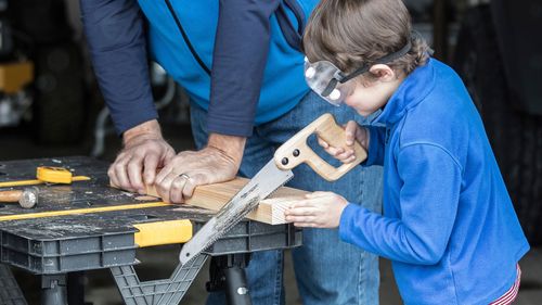 boy and man sawing wood