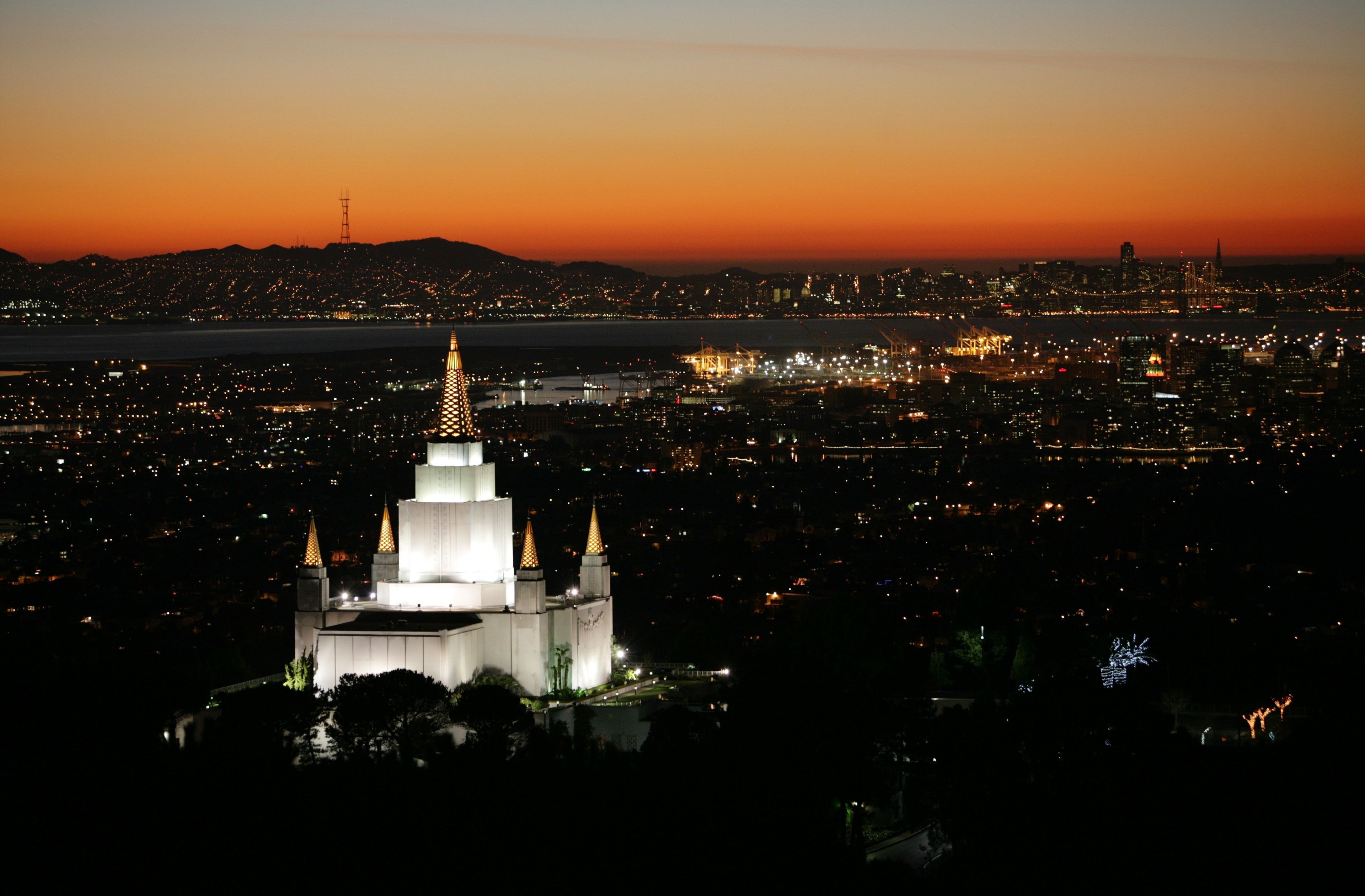 The Oakland California Temple in the evening, including the city.
