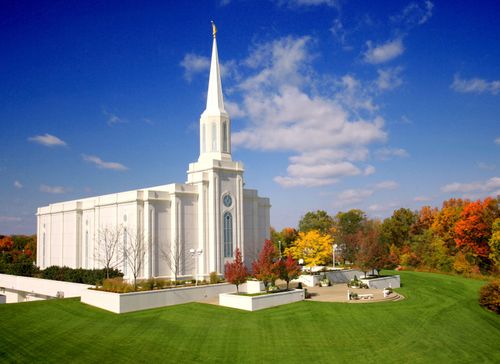 The entire St. Louis Missouri Temple in the fall, with a view of the grounds covered in grass and trees changing colors.