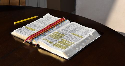 Open scriptures that have been highlighted, on table with ribbon bookmark and yellow pencil. (horiz)