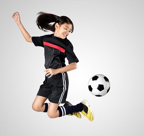 girl with black shirt, black shorts, black socks, and yellow shoes playing football (soccer)