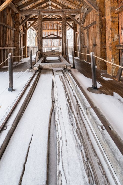 A view of the interior of the sawmill in Kirtland, Ohio, with the ground partially covered in snow.