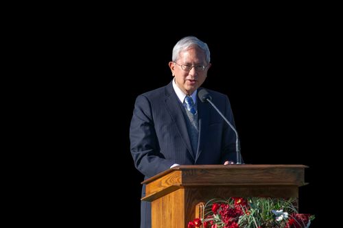 Elder Gong speaking at podium