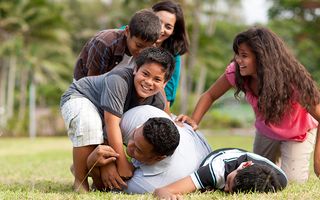 Family playing football - The children tackled the dad