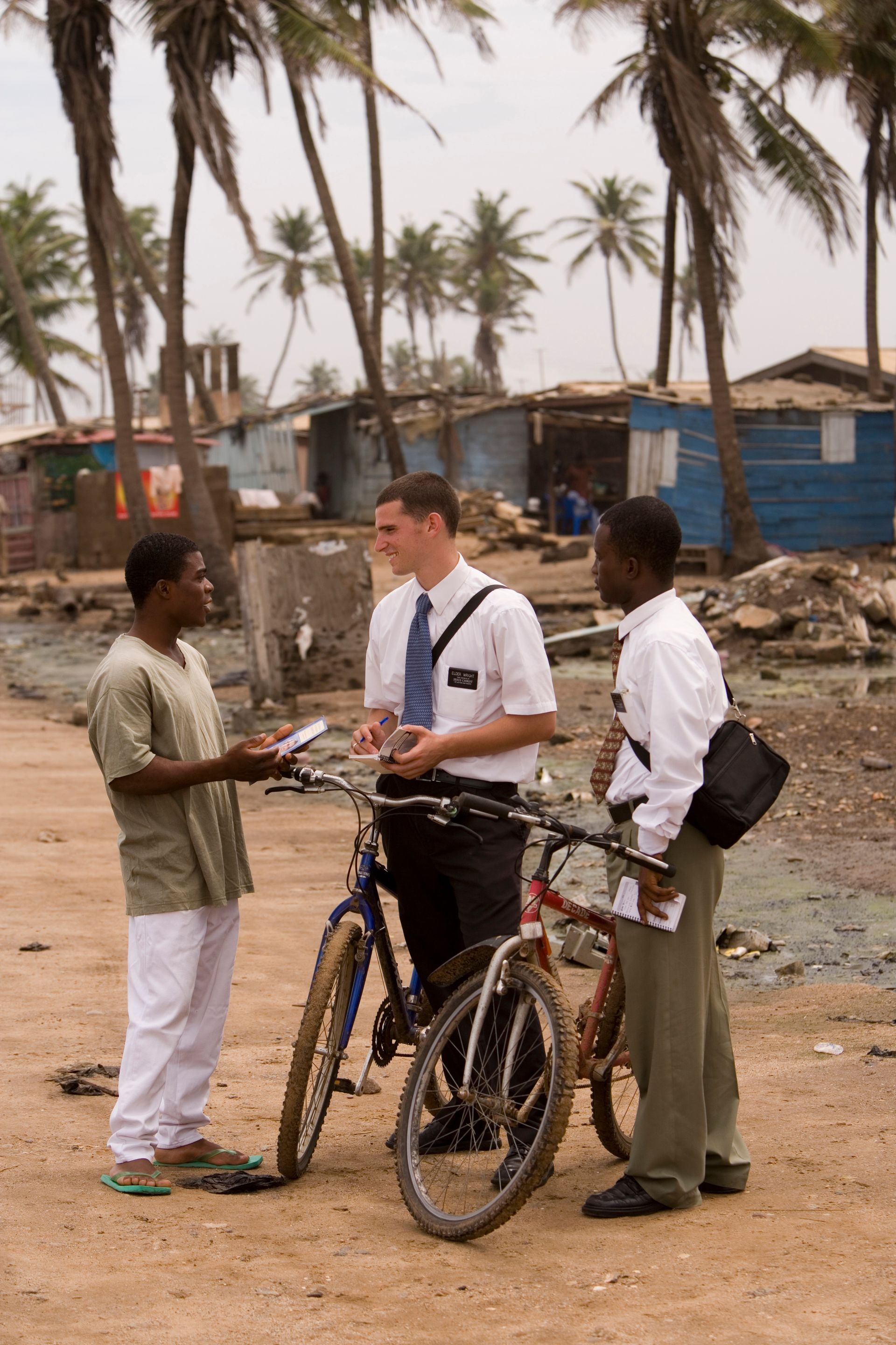 Two elders talking to a man in Ghana.