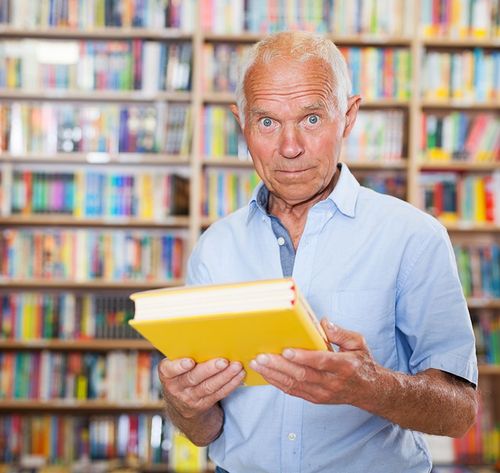 man holding book in library