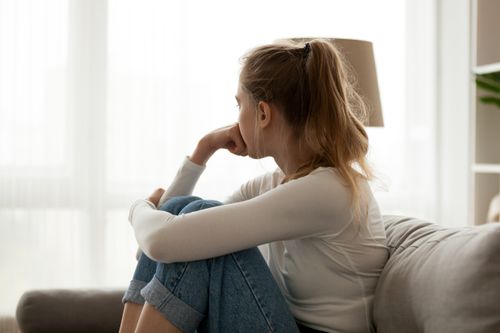 side view of young woman looking out window