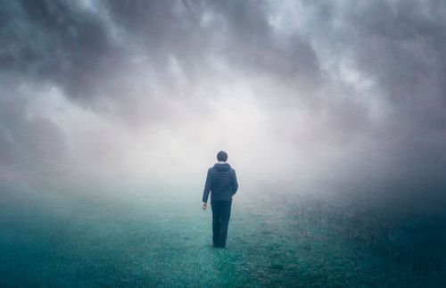 man walking through mist