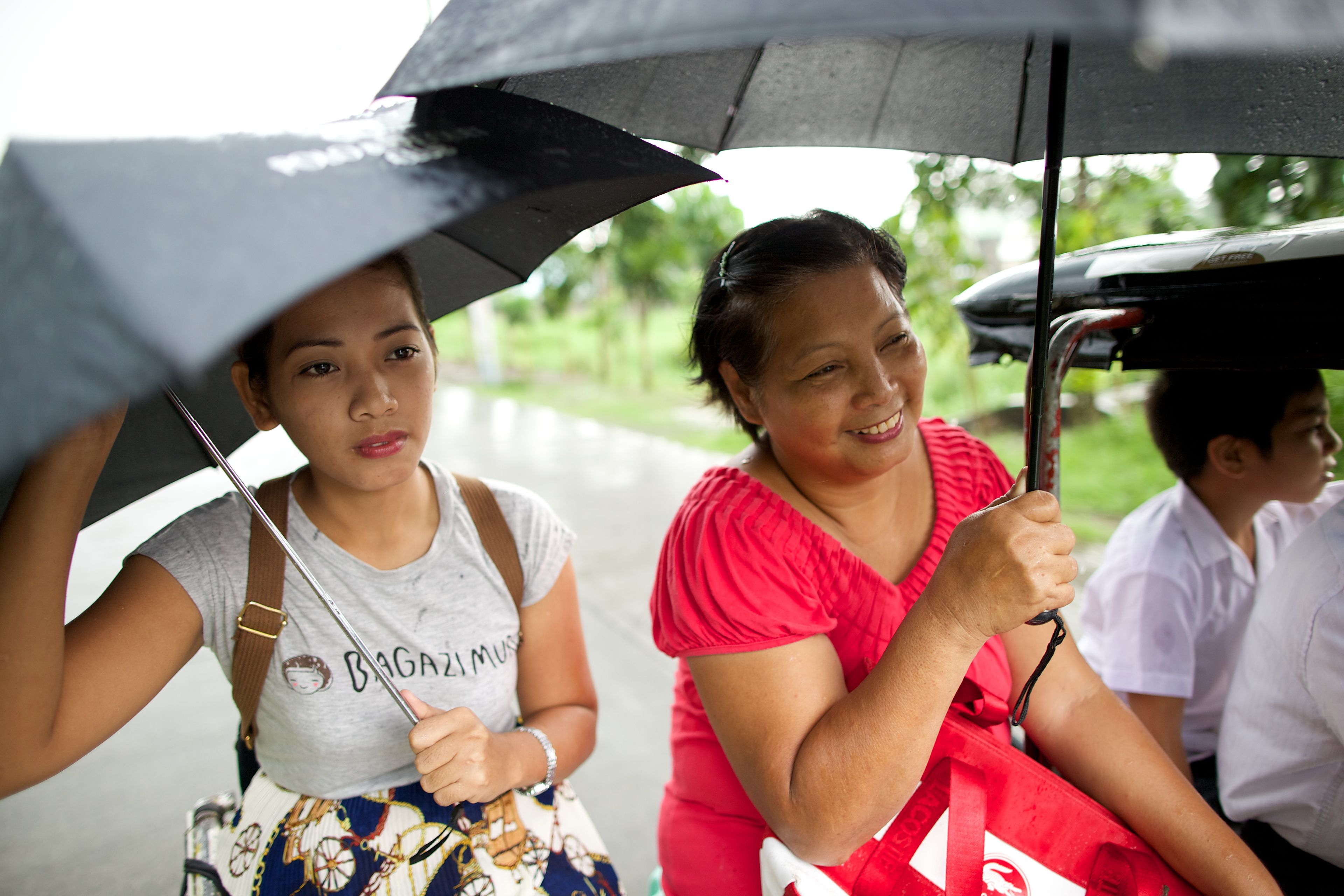 A mother and her daughter travel together on a rainy day.