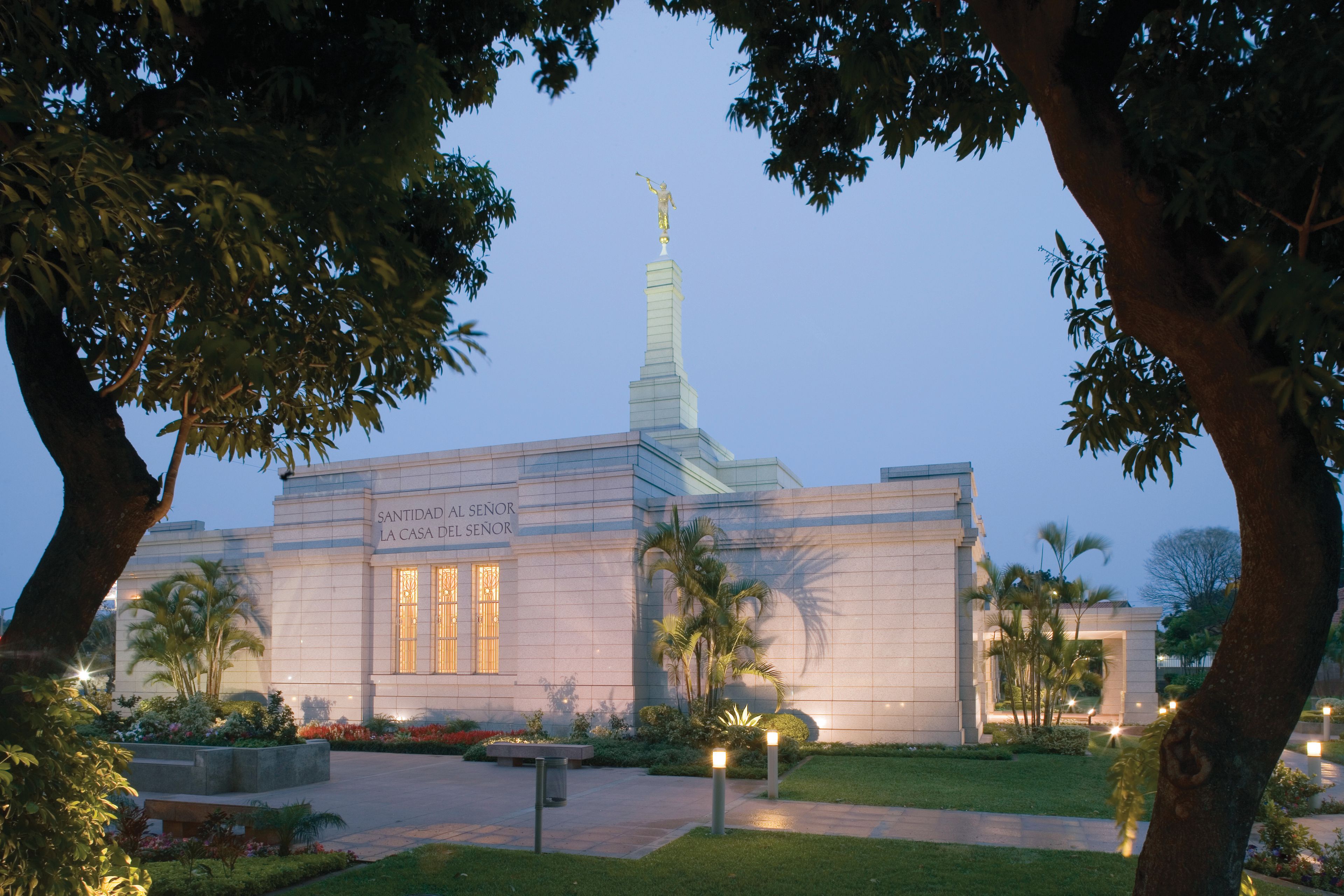 A side view of the exterior of the Asunción Paraguay Temple and grounds at night.