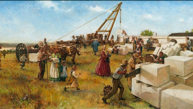 A group of people in a field cutting and moving large white stones.