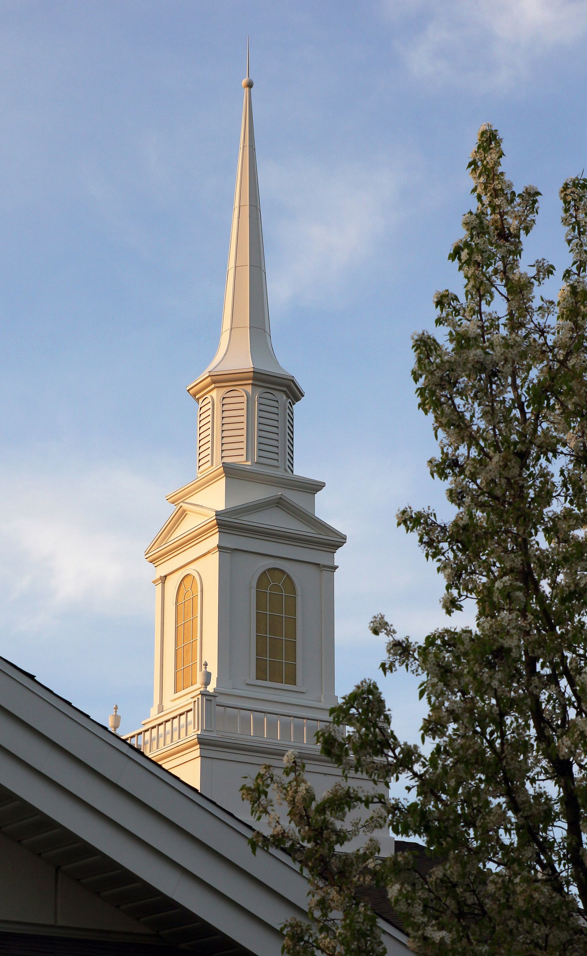 A close-up view of a white steeple in the sky.