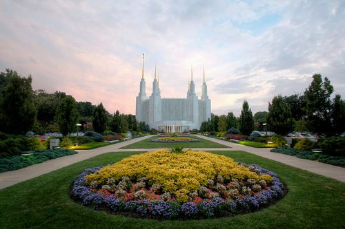 The whole Washington D.C. Temple, with the grounds in front, including flowers and trees at sunset.
