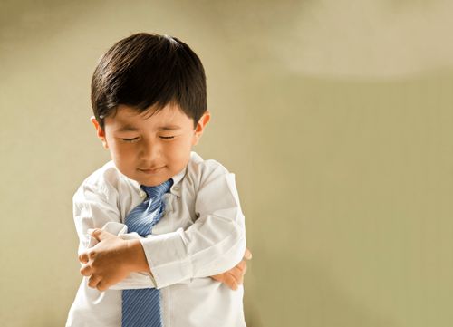 A young boy saying a prayer.
