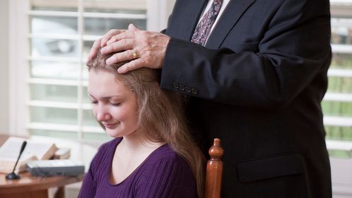 Una joven recibiendo una bendición