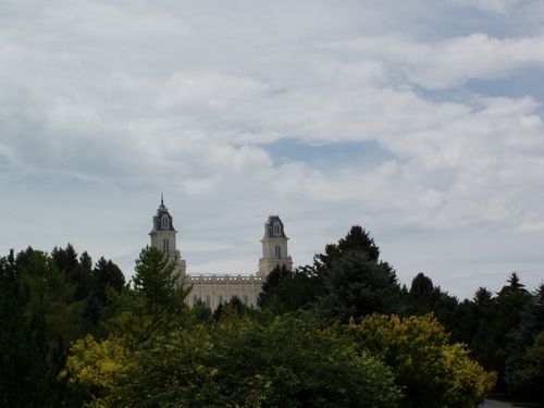 The spires of the Manti Utah Temple are visible from above the tree tops.