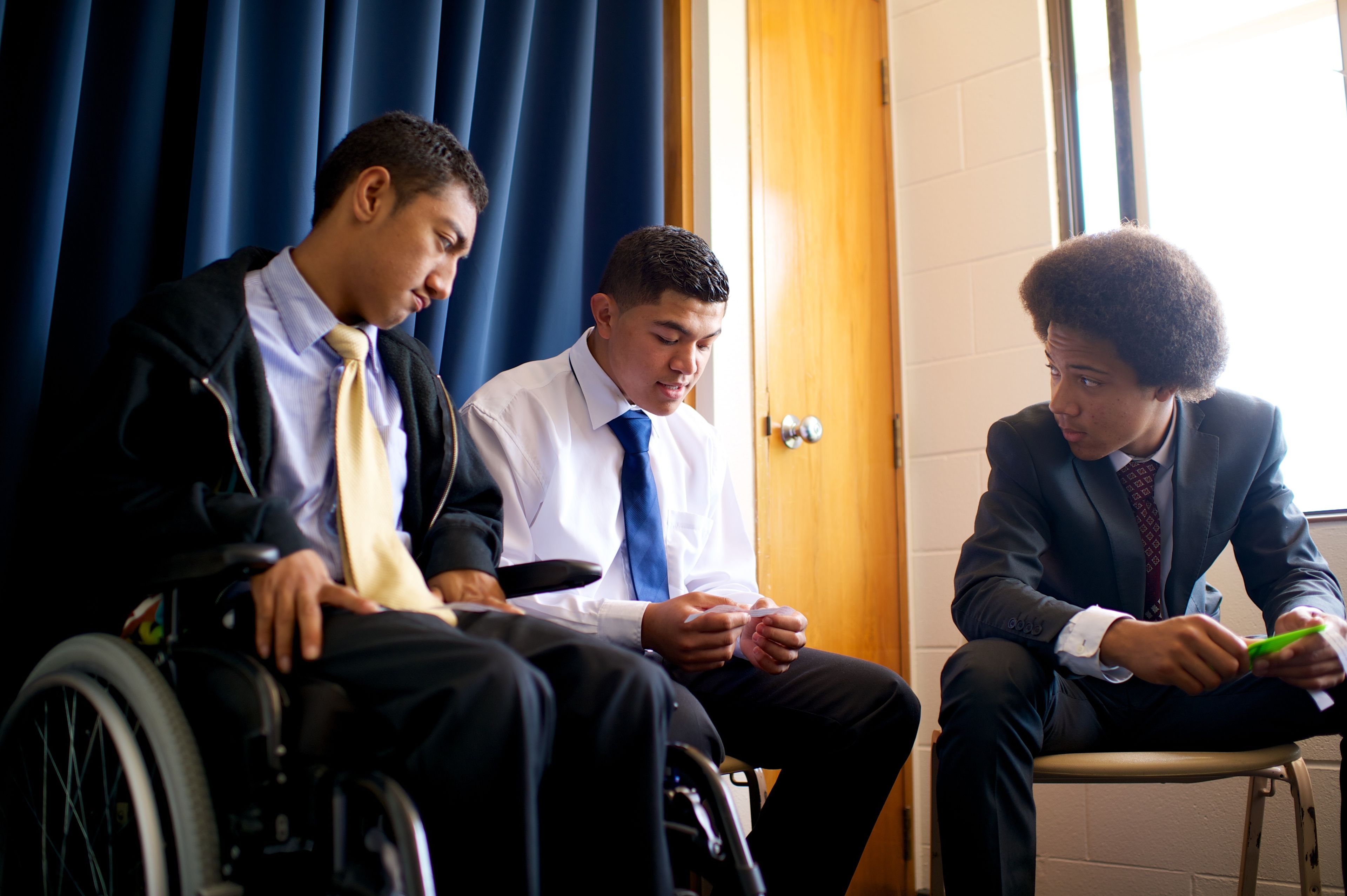 Three young men sit together in Sunday School.