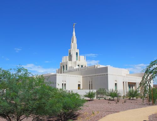 An angle view of the Phoenix Arizona Temple during the day, including scenery and a clear blue sky.