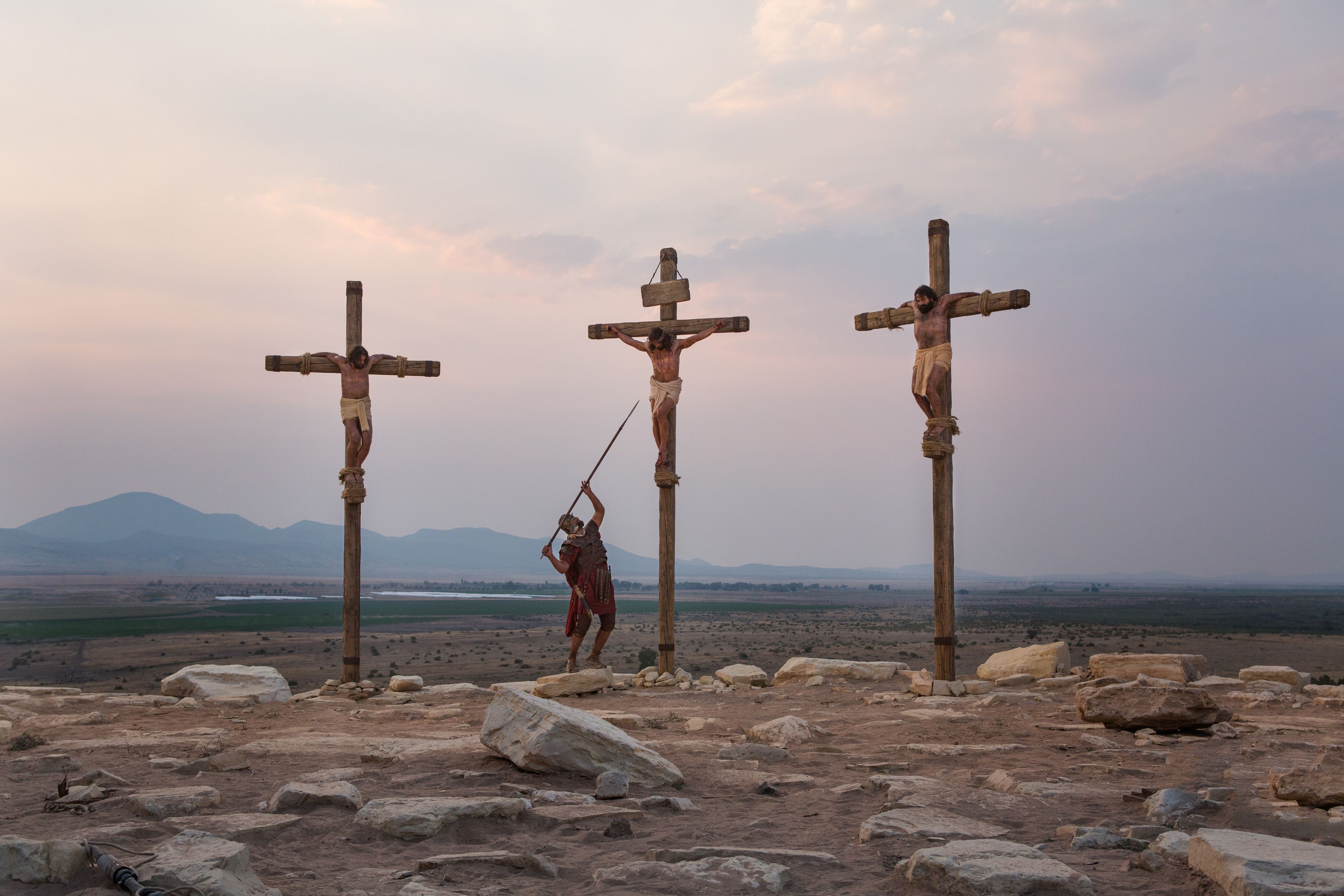 Jesus hangs on the cross between two thieves.