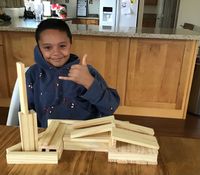 boy behind temple built out of wood