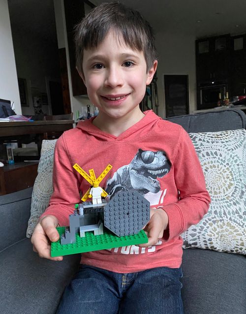 Malachi H. holding an Easter tomb built with plastic blocks 