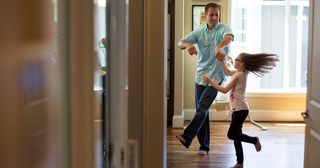 a father dances with his young daughter