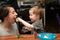 Two year old boy feeds birthday cake to his mom.
