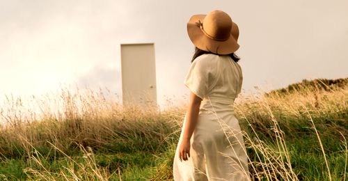 young woman walking toward a door