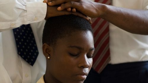 woman receiving priesthood blessing