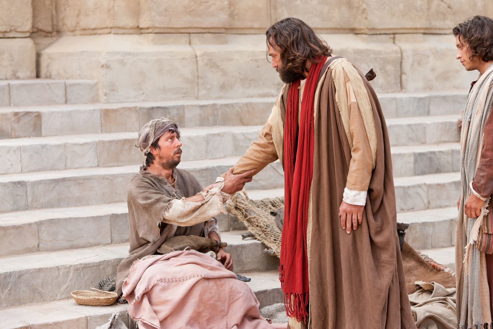 Peter reaches out his hand to a crippled man and commands him to rise and walk.