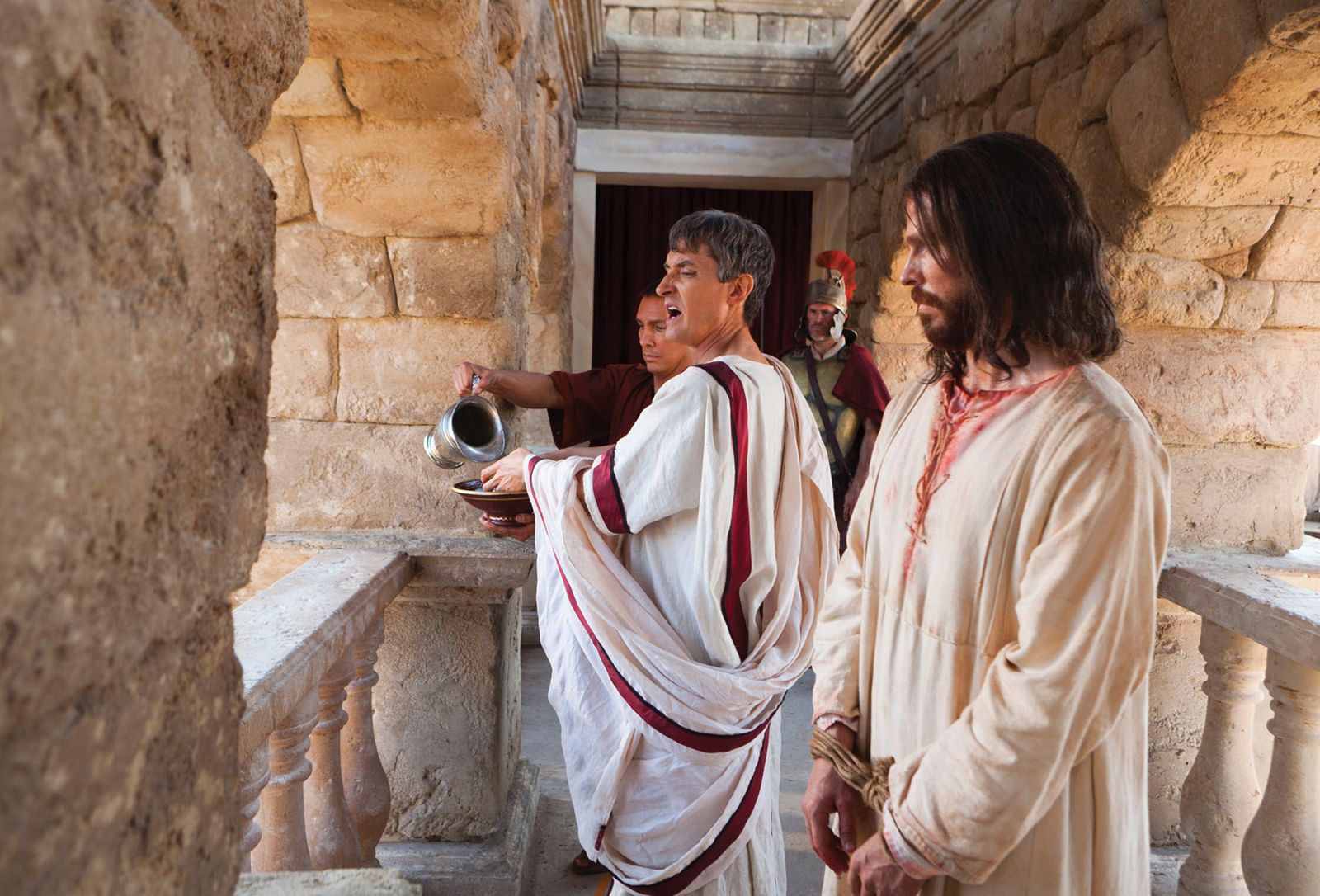 Pilate speaks to the people in the crowd and washes his hands of their accusations of Christ.