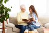 Woman looking at book with her elderly mother