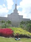 Batang babaeng nakaupo sa harap ng templo