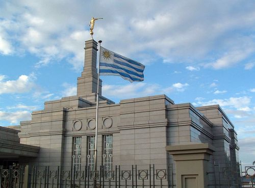 The Uruguayan flag by the front entrance to the Montevideo Uruguay Temple, blowing in the wind in front of the spire and angel Moroni.