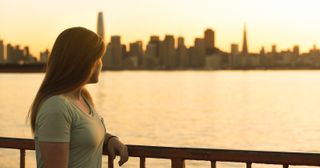 a young adult looks thoughtfully at the sunset