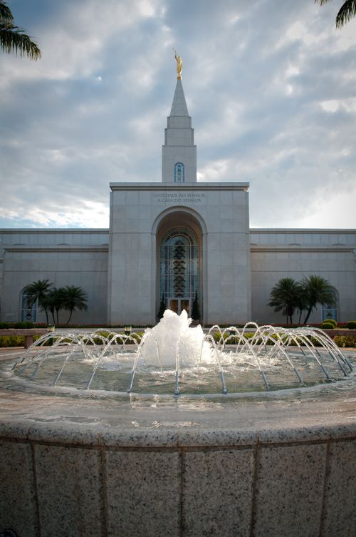 A fountain on the grounds of the Campinas Brazil Temple, with the entrance to the temple seen in the background.