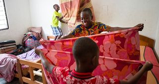 children folding up a piece of cloth