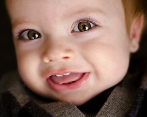 A close-up of a baby boy with brown eyes.