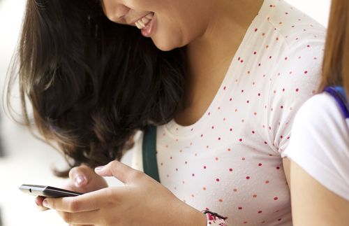 young adult looking at her phone