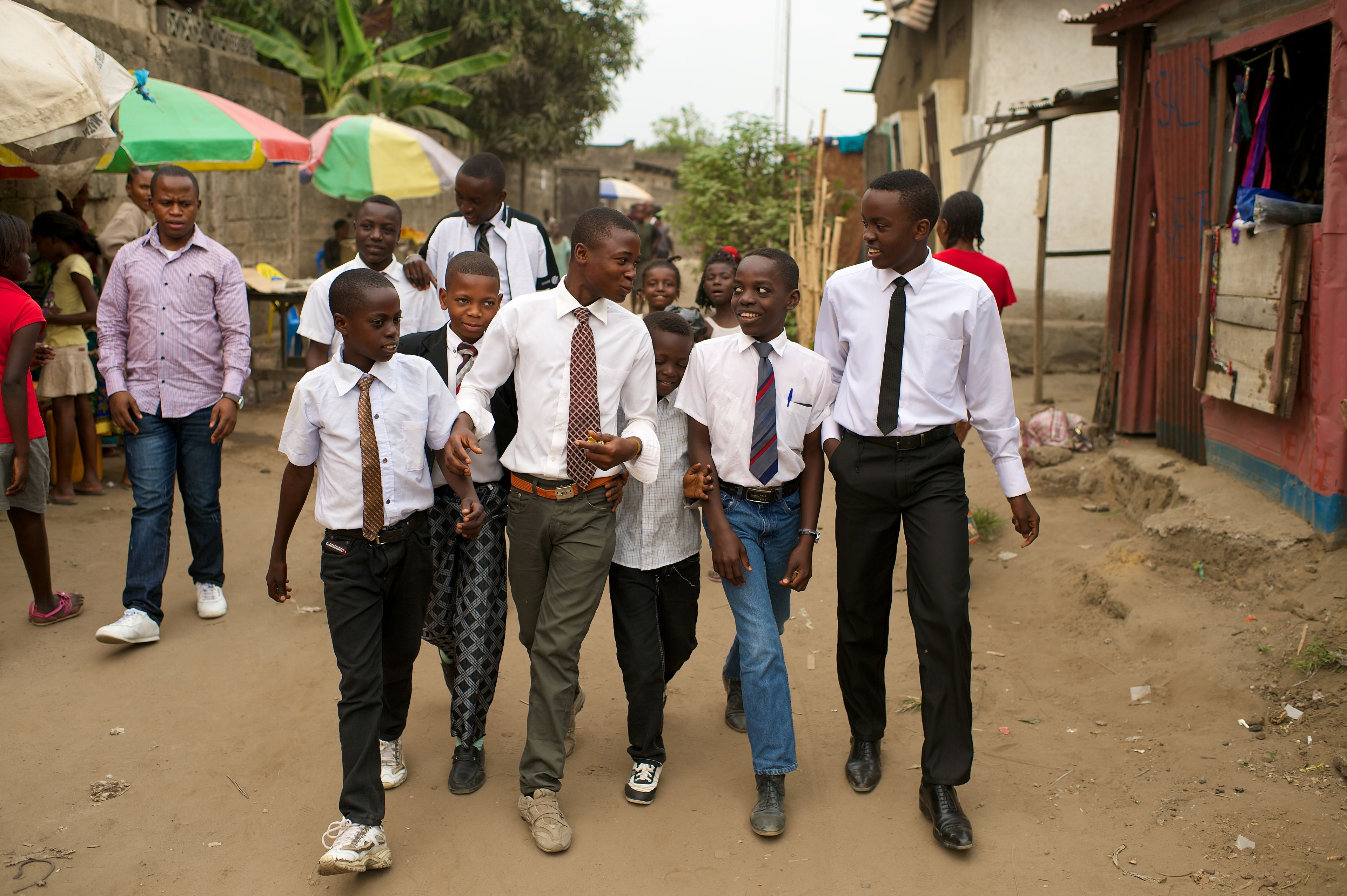 A group of young men from Africa walking in a row down the street.