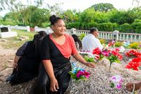 family sitting near grave