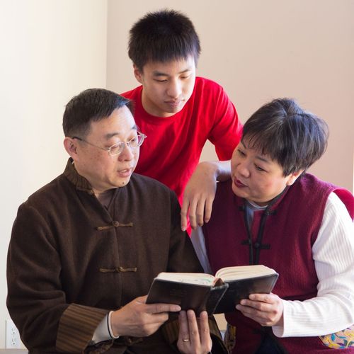 parents reading scriptures with son
