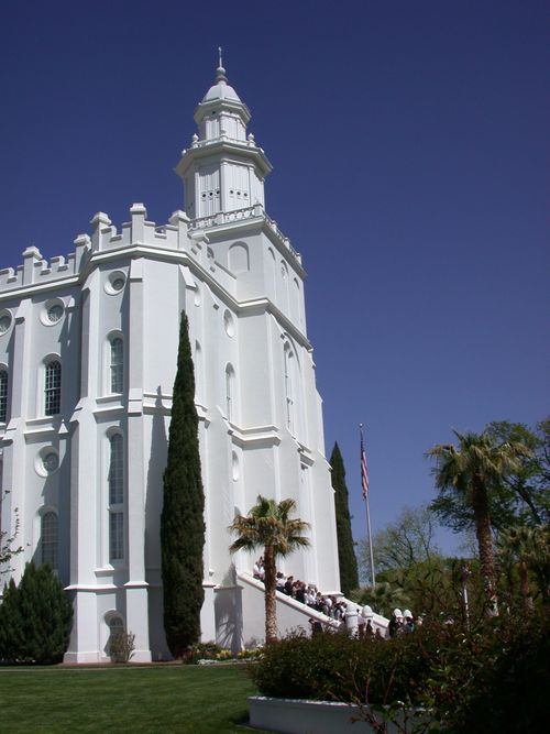 The front of the St. George Utah Temple, with a view of the spire, entrance, and grounds.