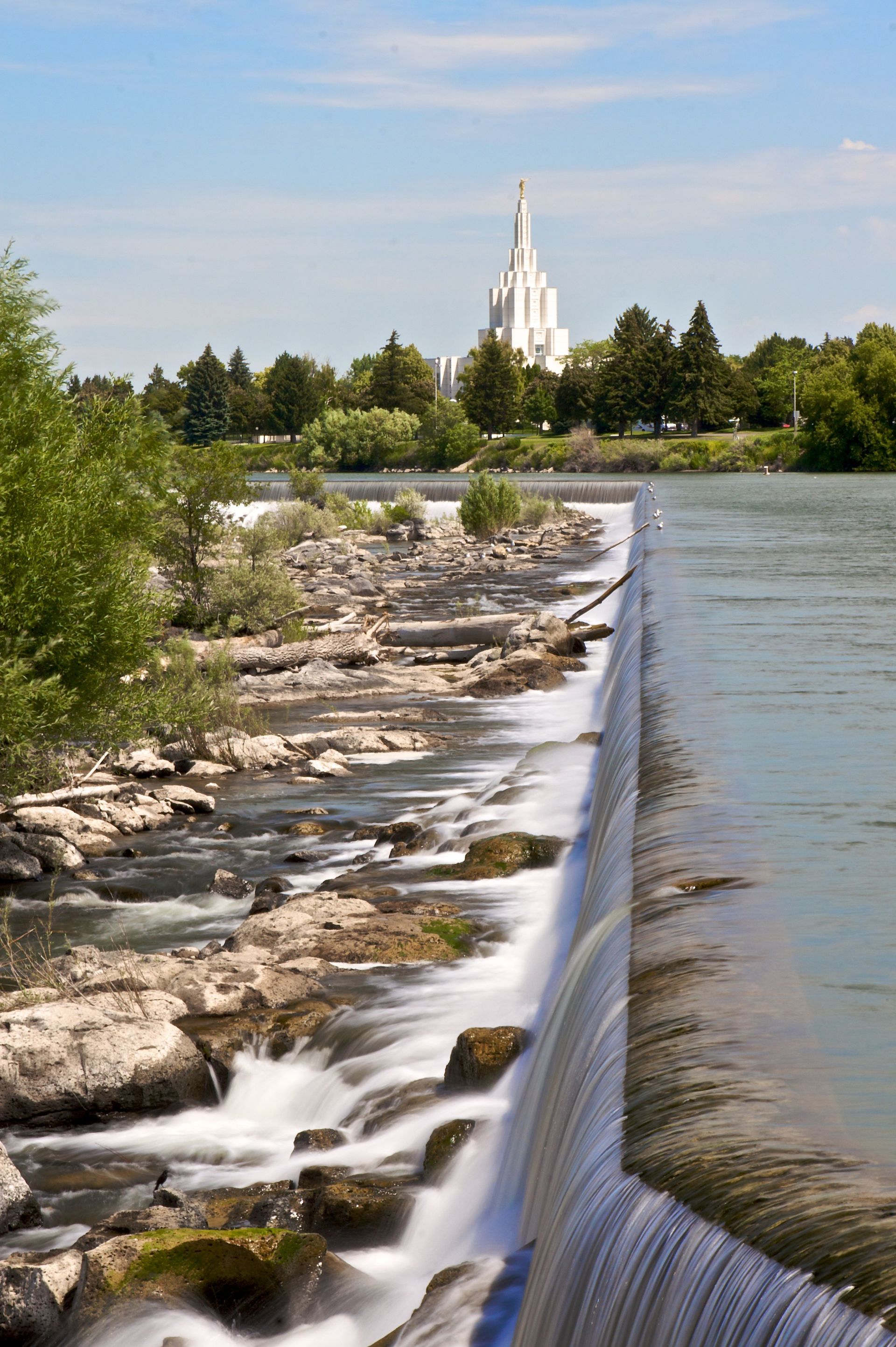 A distant view of the Idaho Falls Idaho Temple, near the waterfalls.