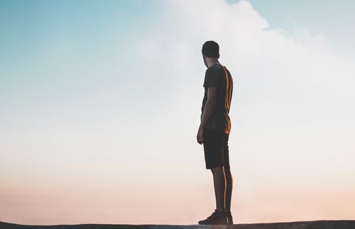 a lone man standing on a mountain