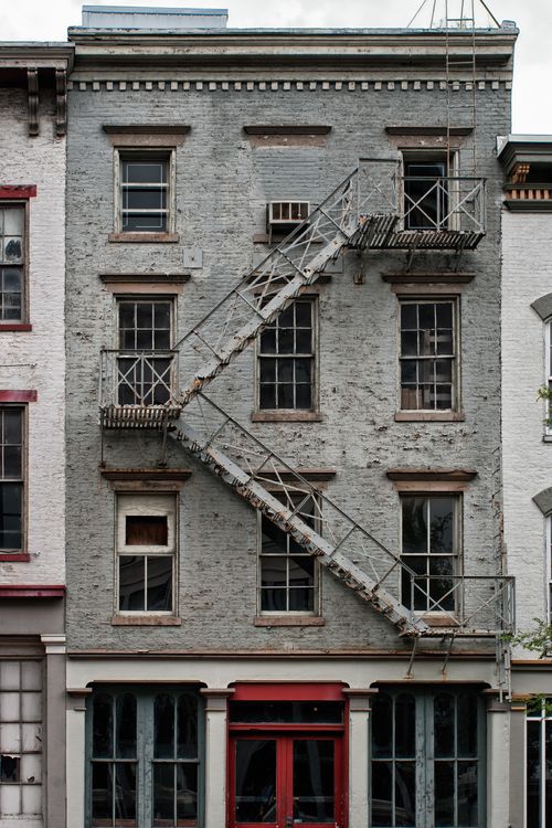 A fire escape outside a gray-brick building with many windows in Louisville, Kentucky.