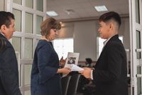 Un muchacho saluda a una pareja entrando la iglesia