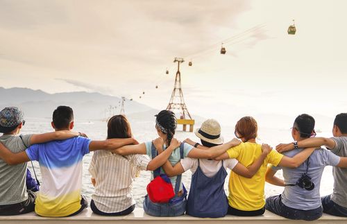 teenagers facing the ocean together